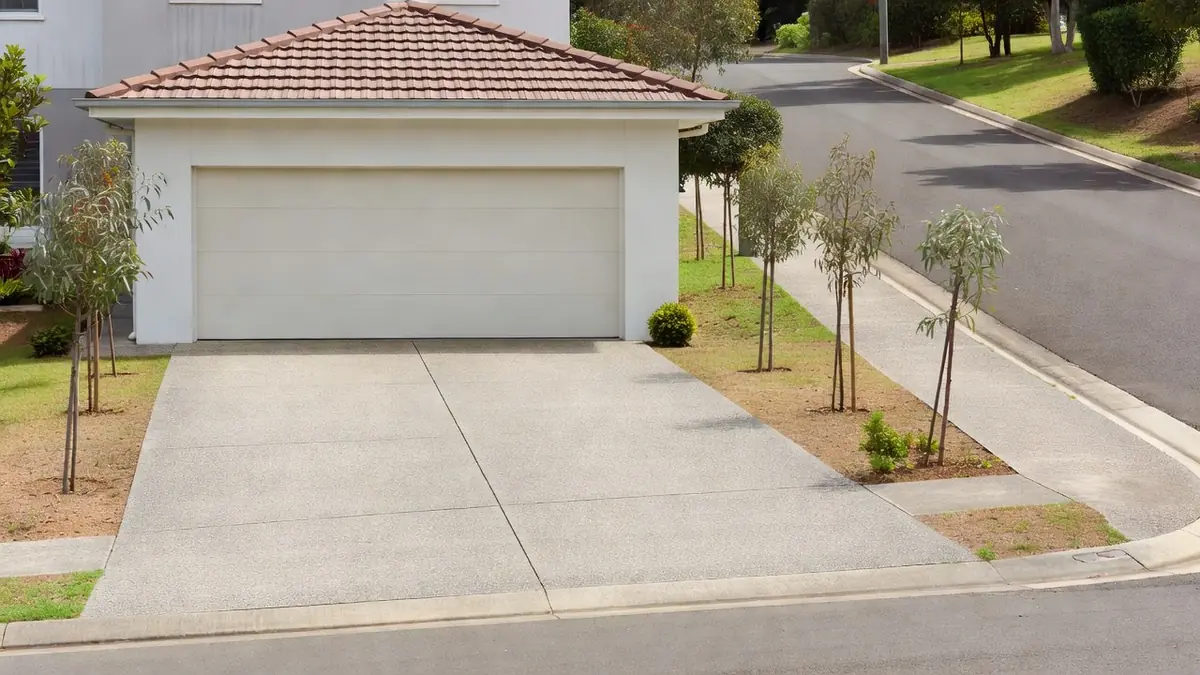 A rendered house with a double panel-lift door and a wide concrete driveway