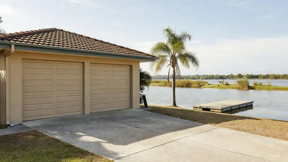 A canal-front house with a double garage door a short way from salt water
