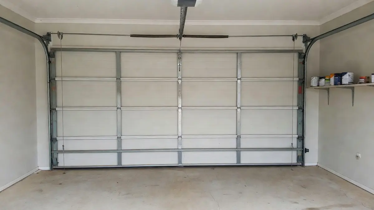 Inside a closed double sectional garage door: the spring bar, lifting cables, rollers, side tracks and opener
