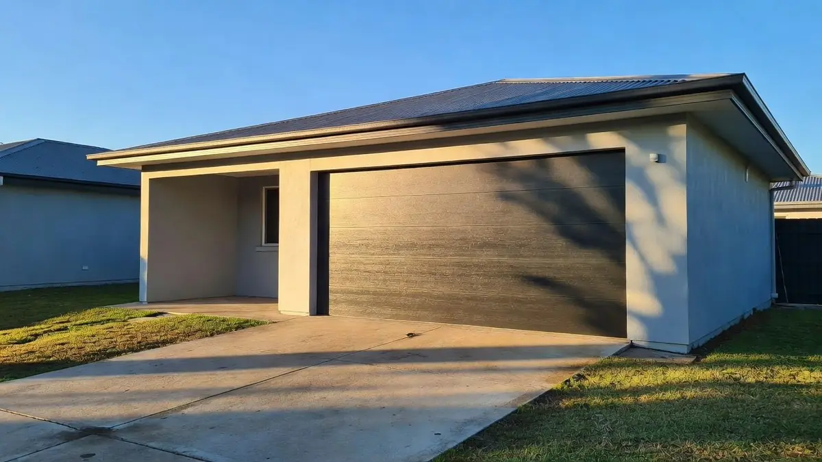 A dark sectional garage door facing west in hard afternoon sun