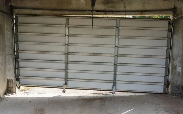 A door hanging crooked with rollers off track
